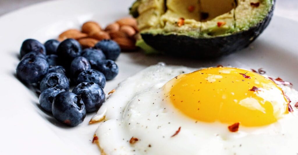 pexels-photo-1305063-1305063 A nutritious breakfast featuring a fried egg, avocado, blueberries, and almonds.
