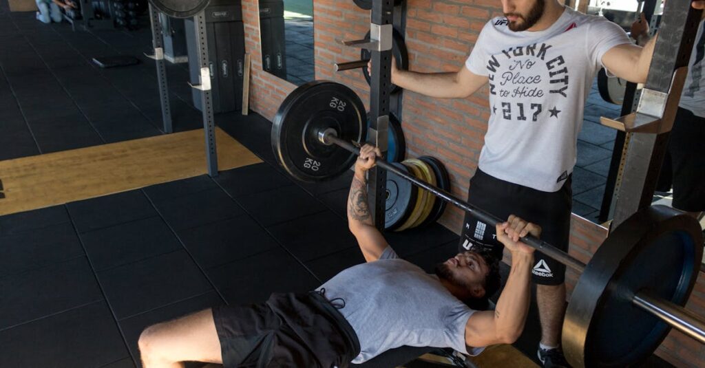 pexels-photo-2204196-2204196 A strong man lifts weights on a bench while a trainer assists in a modern gym setup.