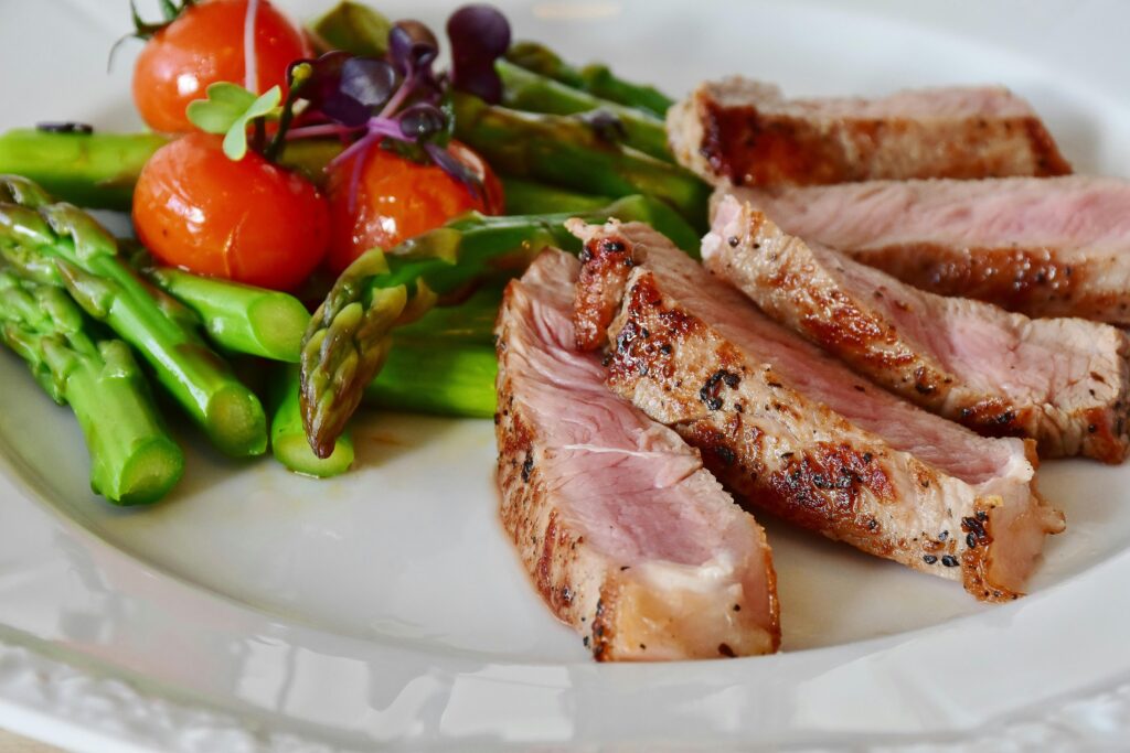asparagus-steak-veal-steak-veal-361184-361184 Close-up of grilled steak slices with asparagus and cherry tomatoes, perfect for a healthy meal.