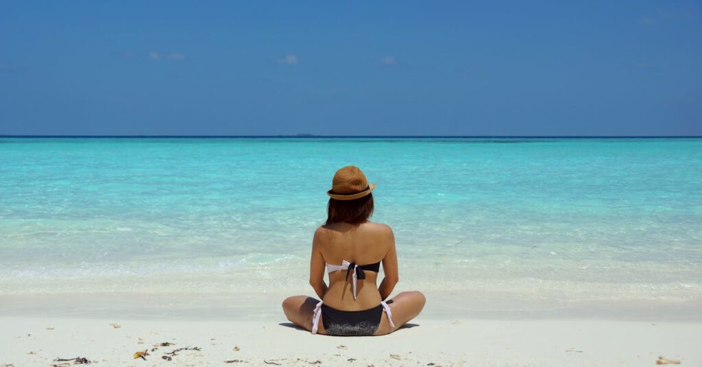 pexels-photo-67818-67818 Rear view of a woman in a bikini and hat relaxing on a pristine beach in Maldives.