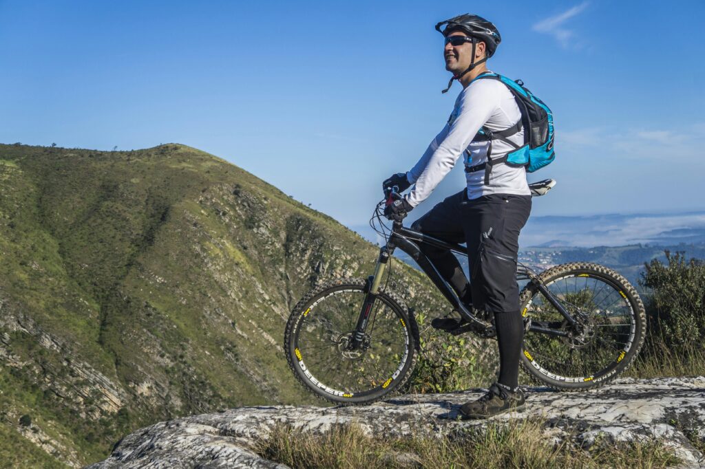 bike-mountain-mountain-biking-trail-163491-163491 Adult cyclist on mountain bike overlooking scenic rocky landscape under clear blue sky.