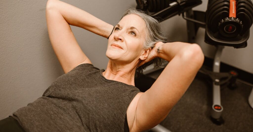 A senior woman performing exercises with dumbbells in a modern fitness center, promoting active lifestyle.